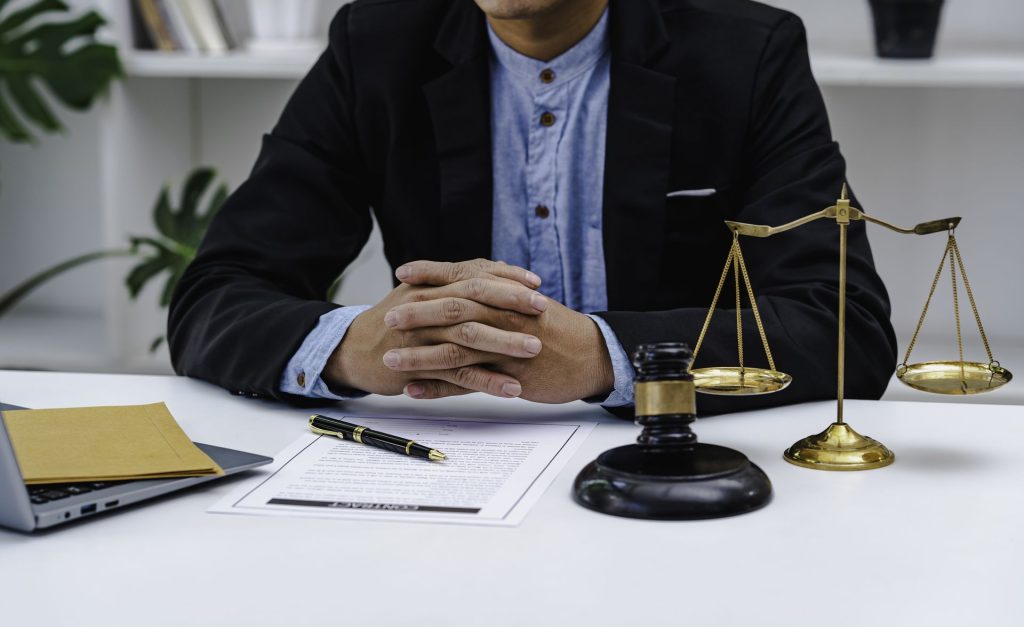 Abogado en su mesa de trabajo con balanza de la justicia y mazo